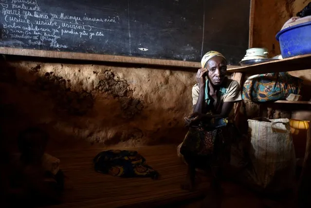 An internally displaced Congolese woman and her child sit inside a classroom used by victims of ethnic violence in Iga Barriere, Ituri province, in the eastern Democratic Republic of Congo on June 24, 2019. (Photo by Olivia Acland/Reuters)