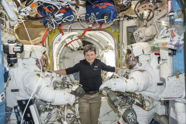 In this January 13, 2017 photo made available by NASA, astronaut Peggy Whitson, center, floats inside the Quest airlock of the International Space Station with Thomas Pesquet, left, and Shane Kimbrough before their spacewalk. On Wednesday, April 5, 2017, NASA announced that Whitson will remain on the ISS until September 2017, adding three months to her original mission. (Photo by NASA via AP Photo)
