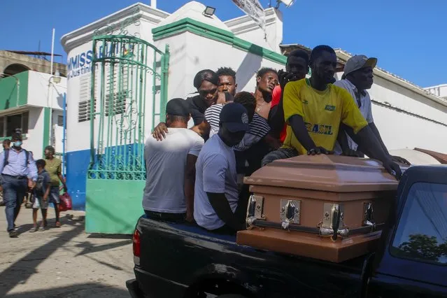 Relatives carry the remains of a woman who died at Justinien University Hospital from her burn injuries caused by a gasoline truck that overturned and exploded, in Cap-Haitien Haiti, Wednesday, December 15, 2021. (Photo by Joseph Odelyn/AP Photo)