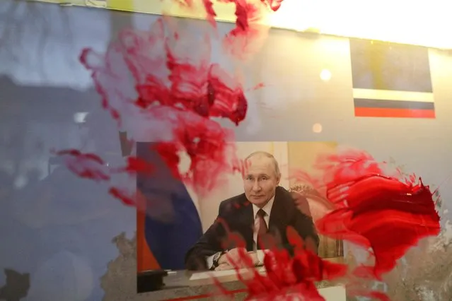 Red paint is seen smeared over a portrait of Russian President Vladimir Putin during an anti-war protest outside the Russian Embassy in Bucharest, Romania, February 26, 2022. (Photo by Octav Ganea/Inquam Photos via Reuters)