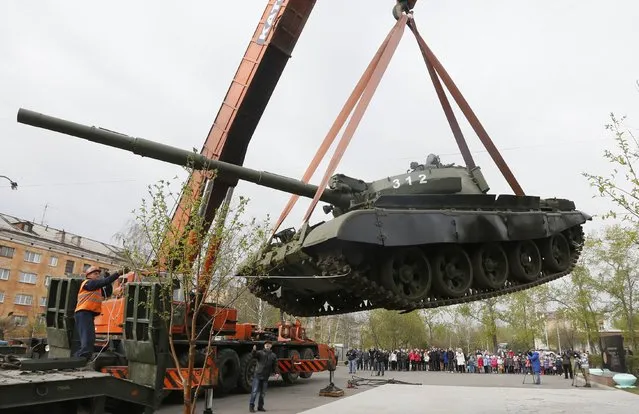 Workers install a demilitarized Soviet-made T-62M1 tank at a memorial in a park in Russia's Siberian city of Krasnoyarsk April 30, 2014. (Photo by Ilya Naymushin/Reuters)