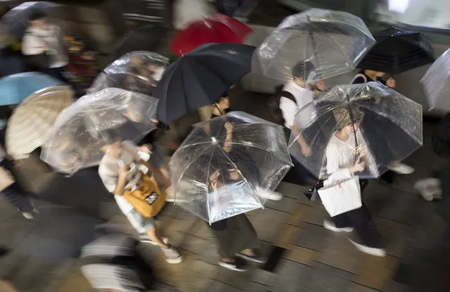 Evening commuters make their way along Omotesando avenue during a downpour in the Shibuya neighbourhood of Tokyo on September 18, 2019. (Photo by Odd Andersen/AFP Photo)