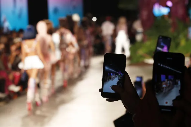 Spectators record on their cell phones as models wear creations as part of the GCDS Spring-Summer 2020 collection, unveiled during the fashion week, in Milan, Italy, Saturday, September 21, 2019. (Photo by Antonio Calanni/AP Photo)