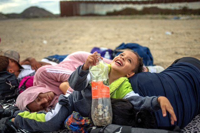 Dylan, a four year old migrant from Mexico, smiles while playing with his aunt Daniela, 24, as his parents Ivan, 22, and Rubi, 22, sleep on the left after the Rivera family crossed the Border Wall into the United States from Mexico in Ruby, Arizona on June 26, 2024. (Photo by Adrees Latif/Reuters)