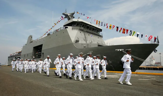 Philippine Navy personnel jog past Strategic Sealift Vessel BRP Tarlac LD601 to board their vessel nearby, during the commissioning ceremony of the newly acquired BRP Tarlac and three Landing Craft Heavies (LCHs) at the celebration of Philippine Navy's 118th anniversary in Manila, Philippines June 1, 2016. (Photo by Erik De Castro/Reuters)