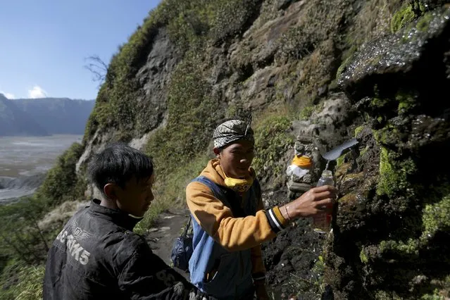 Hindu villagers collect holy water from a stream for prayers ahead of the annual Kasada festival at Mount Bromo in Indonesia's East Java province, July 30, 2015. (Photo by Reuters/Beawiharta)