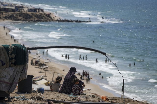 Palestinians displaced by the war between Israel and Hamas, take refuge in a tented settlement along the Mediterranean Sea shore, west of Deir al-Balah, Gaza Strip, August 20, 2024. (Photo by Abdel Kareem Hana/AP Photo)