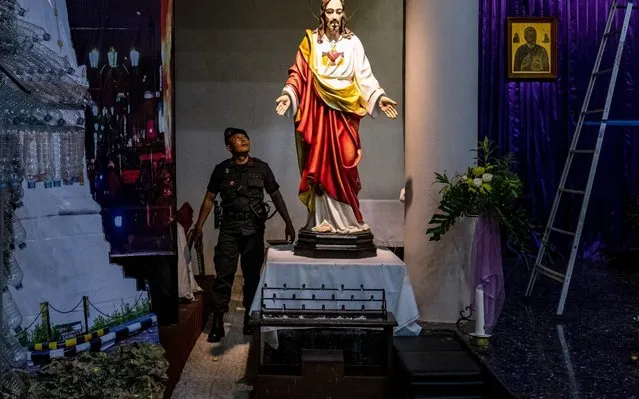A member of the police bomb squad makes a security sweep before the Christmas celebration at Santo Alfonsus De Liguori Nandan Catholic Church on December 23, 2019 in Yogyakarta, Indonesia. Christmas is a national holiday in Indonesia, despite only eight percent of the population identifying as Christian. (Photo by Ulet Ifansasti/Getty Images)