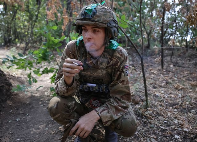 Sasha, 22, a member of the unit who previously worked as a welder, enjoys a cigarette near Pokrovsk on September 5, 2024. (Photo by Serhiy Nuzhnenko/Radio Free Europe/Radio Liberty)