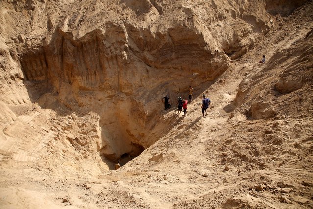 Palestinians gather to inspect a site excavated by Israeli forces after their withdrawal from the area, following a ground operation, amid the ongoing conflict between Israel and Hamas, in Khan Younis, in the southern Gaza Strip, on August 30, 2024. (Photo by Hatem Khaled/Reuters)