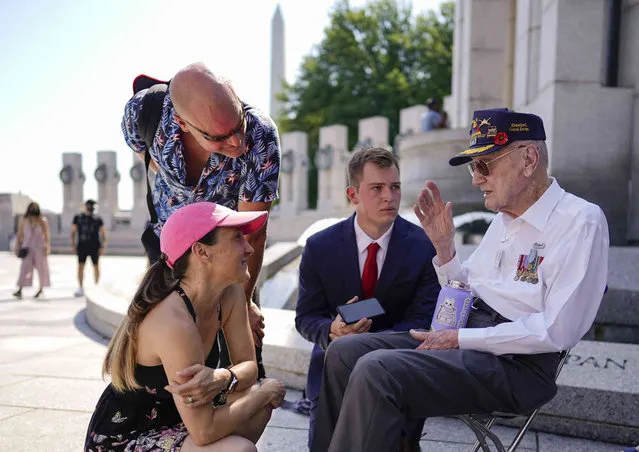 World War II Veteran, retired U.S. Air Force Senior Master Sgt. Harry Miller, 93, right, recalls his time in the service with Peter Lynch, second from right, and others, at the World War II Memorial on Memorial Day in Washington, Monday, May 30, 2022. During WW II, Harry served in the 740th Tank Battalion as a tank crewman and participated in the “The Battle of the Bulge”. (Photo by Carolyn Kaster/AP Photo)
