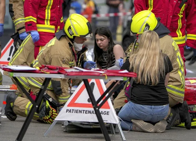 Rescue workers help an injured person after a car crashed into a crowd of people in central Berlin, Germany, Wednesday, June 8, 2022. (Photo by Michael Sohn/AP Photo)
