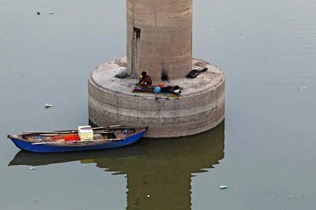 Men rest on a pillar of a bridge over the river Ganga on a hot summer day in Allahabad, India, June 25, 2016. (Photo by Jitendra Prakash/Reuters)