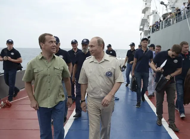 Russian President Vladimir Putin (C) listens to Prime Minister Dmitry Medvedev (L) after submerging into the waters of the Black Sea inside a research bathyscaphe as part of an expedition near Sevastopol, Crimea, August 18, 2015. (Photo by Alexei Nikolsky/Reuters/RIA Novosti/Kremlin)