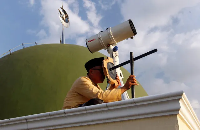 A Muslim man uses a traditional tool to look at the position of the moon near the end of the holy fasting month of Ramadan at Al-Musyari'in mosque in Jakarta, Indonesia, July 4, 2016. (Photo by Iqro Rinaldi/Reuters)