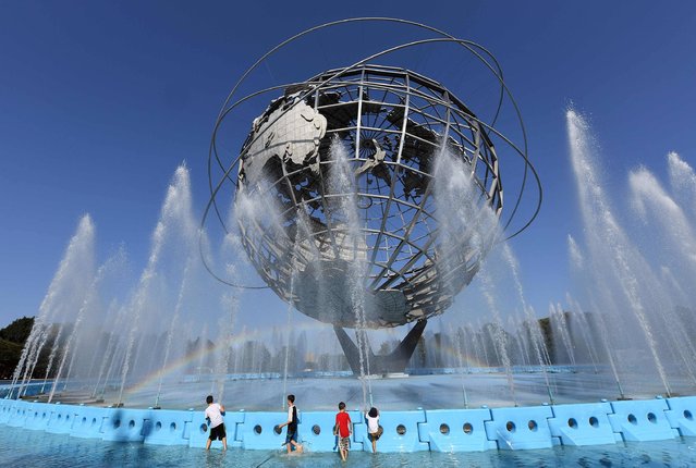 Children play in the fountain by the Unisphere steel structure at Flushing Meadows-Corona Park during the 2017 US Open at the USTA Billie Jean King National Tennis Center in New York on August 30, 2017. (Photo by Angela Weiss/AFP Photo)