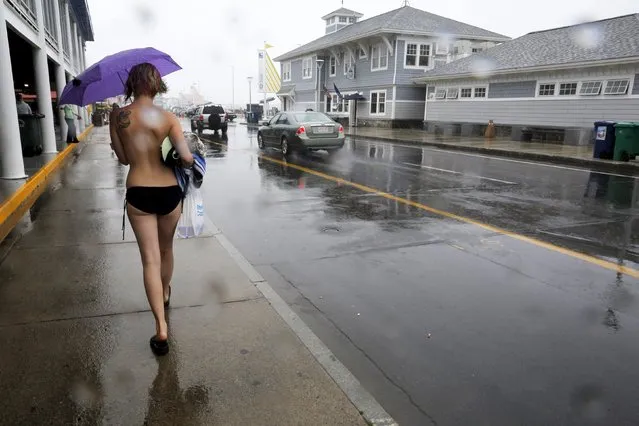 Topless activist Kaila J. walks through the rain following a “Free the Nipple” demonstration in Hampton Beach, New Hampshire August 23, 2015. (Photo by Brian Snyder/Reuters)