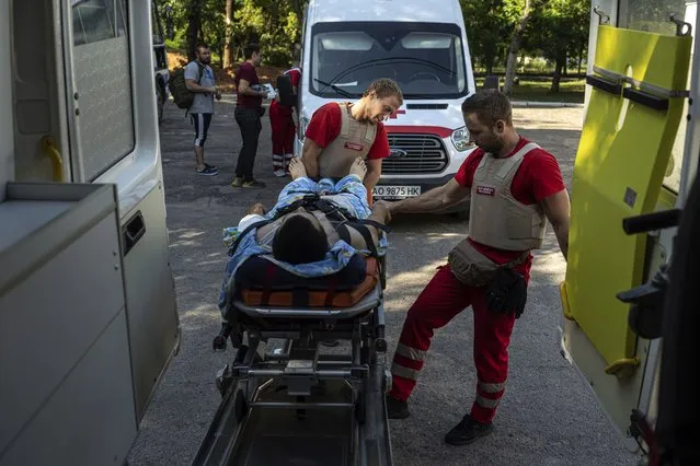 Volunteers of the Ukrainian Red Cross emergency transport a wounded man from one to another hospital in Mykolaiv, Ukraine, Tuesday, August 9, 2022. (Photo by Evgeniy Maloletka/AP Photo)