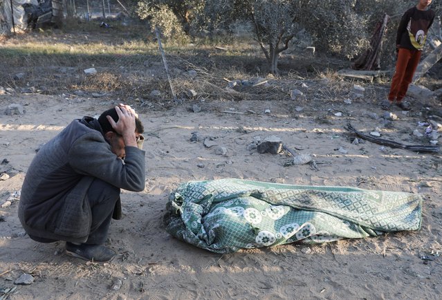 A person reacts next to a body, in the aftermath of an Israeli strike on a house, amid the Israel-Hamas conflict , in Deir Al-Balah, in the central Gaza Strip, on December 22, 2024. (Photo by Ramadan Abed/Reuters)