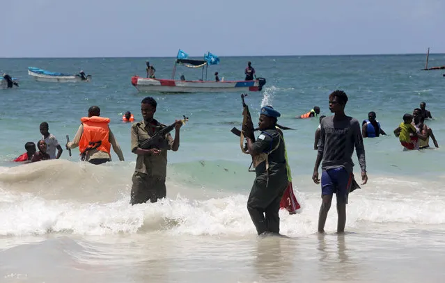 A Somali policeman attempts to disperse revellers swimming in the Indian Ocean near Lido beach, as part of measures to prevent the potential spread of coronavirus (COVID-19), in Mogadishu, Somalia on April 3, 2020. (Photo by Feisal Omar/Reuters)