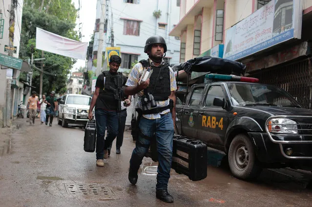 Policemen return after rafter a raid on a building in Dhaka, Bangladesh, Tuesday, July 26, 2016. (Photo by AP Photo)