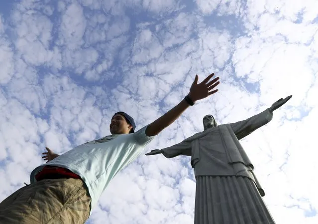 A tourist poses under the Christ the Redeemer statue in Rio de Janeiro, Brazil August 6, 2016. (Photo by Leonhard Foeger/Reuters)