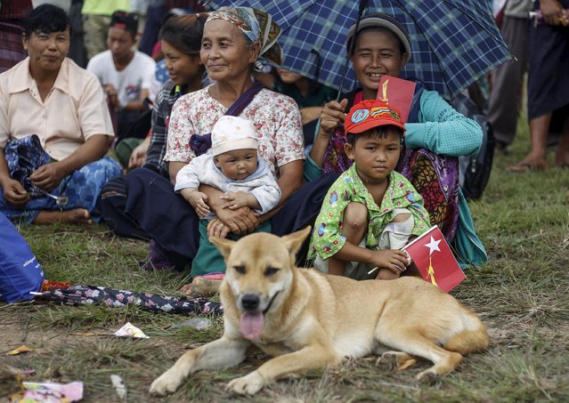 A family and their dog sit as they wait for Myanmar pro-democracy leader Aung San Suu Kyi's speech during her campaign for the upcoming general election, in Demoso, Kayah state September 10, 2015. (Photo by Soe Zeya Tun/Reuters)