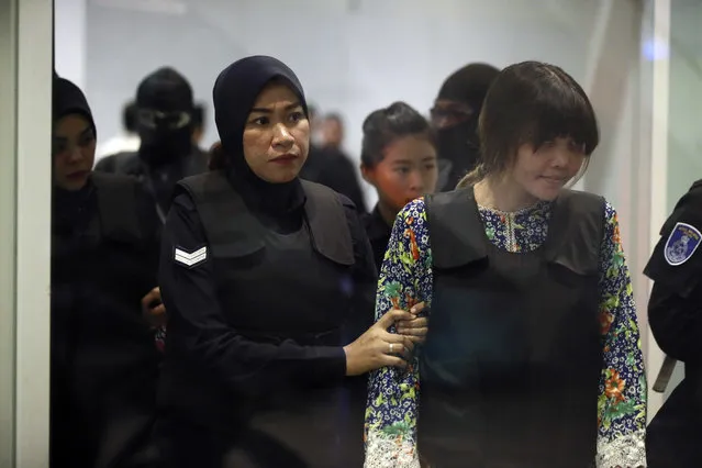 Vietnamese Doan Thi Huong, right, is escorted by police as she arrives for re-enactment of the murder of the estranged half brother of North Korea's leader, at the KLIA2 budget terminal in Sepang, Malaysia, Tuesday, October 24, 2017. (Photo by Sadiq Asyraf/AP Photo)