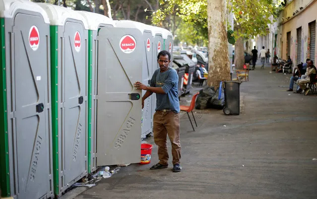 A migrant exits a chemical toilet at a makeshift camp in Via Cupa (Gloomy Street) in downtown Rome, Italy, August 1, 2016. (Photo by Max Rossi/Reuters)