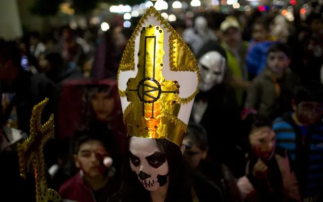 A person dressed in a Catholic priest zombie costume participates in the annual Zombie Walk in La Paz, Bolivia, late Saturday, October 28, 2017. This annual walk is a Halloween charity event to collect money to feed street animals, according to organizers. (Photo by Juan Karita/AP Photo)
