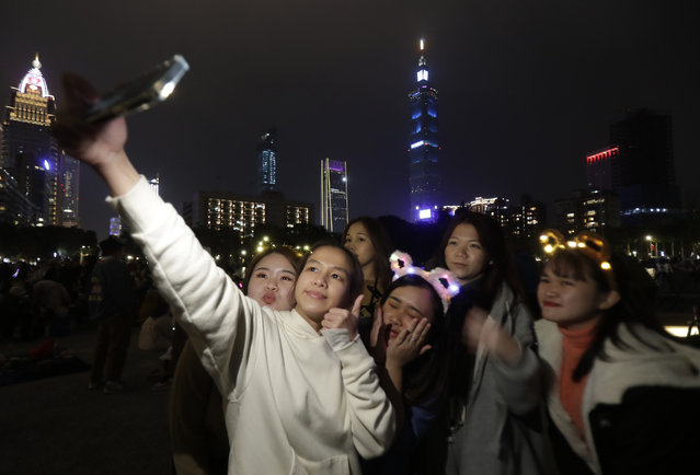 People wear New Year's costumes and take photo to wait the turn of the year in Taipei, Taiwan, Sunday, December 31, 2023. (Photo by Chiang Ying-ying/AP Photo)