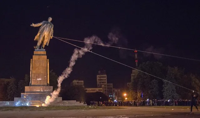Activists dismantle Ukraine's biggest monument to Lenin at a pro-Ukrainian rally in the central square of the eastern city of Kharkiv, Ukraine, Sunday, September 28, 2014. (Photo by Igor Chekachkov/AP Photo)