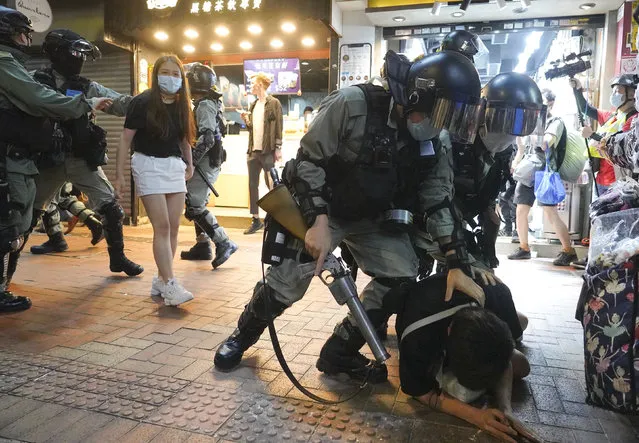 Hong Kong Riot police detain a protester during a protest in Causeway Bay, Hong Kong, Friday, June 12, 2020. (Photo by Vincent Yu/AP Photo)