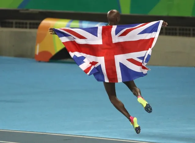 Mo Farah of Great Britain carries his countries flag after winning the gold medal in the men's 5000m Final race, August 20, 2016. (Photo by Antonio Lacerda/EPA)