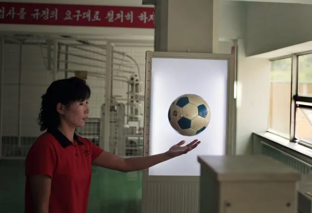 A worker catches a ball after performing a bounce test at the newly opened Pyongyang Sports Equipment Factory in Pyongyang, North Korea, Monday, August 22, 2016. Despite claiming only two gold medals in Rio, North Korea is as determined as ever to fulfill one of leader Kim Jong Un’s primary goals: to become an international sports superpower. (Photo by Dita Alangkara/AP Photo)