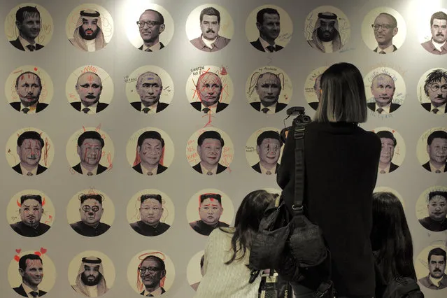 A wall showing doodle marks on portraits of various dictators is seen during the Oslo Freedom Forum in Taipei on November 3, 2022. (Photo by Sam Yeh/AFP Photo)