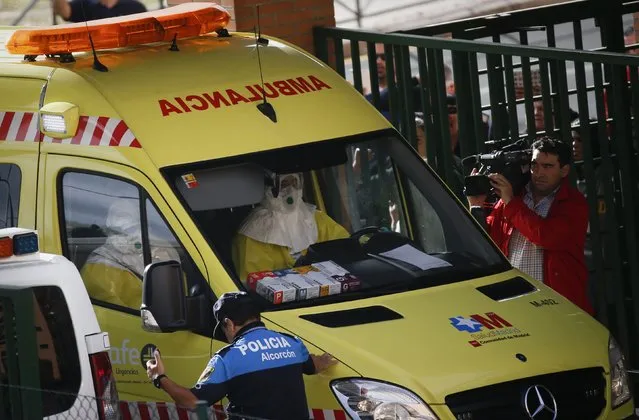 An ambulance crew drives through the entrance of the apartment building of the nurse who contracted Ebola, in Alcorcon, outside Madrid, October 8, 2014. Spanish health authorities said on Wednesday that another person being monitored in Madrid for Ebola had tested negative for the disease. The man, a Spaniard who had travelled from Nigeria, was one of several people hospitalised after authorities confirmed on Monday that a Spanish nurse had caught the disease in Madrid. (Photo by Susana Vera/Reuters)