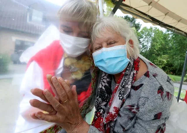 Lily Hendrickx, 83, a resident at Belgian nursing home “Le Jardin de Picardie” enjoy hugs and cuddles with Marie-Christine Desoer, the director of the residence, through a wall made with plastic sheets to protect against potential coronavirus disease (COVID-19) infection, in Peruwelz, Belgium on July 1, 2020. (Photo by Yves Herman/Reuters)