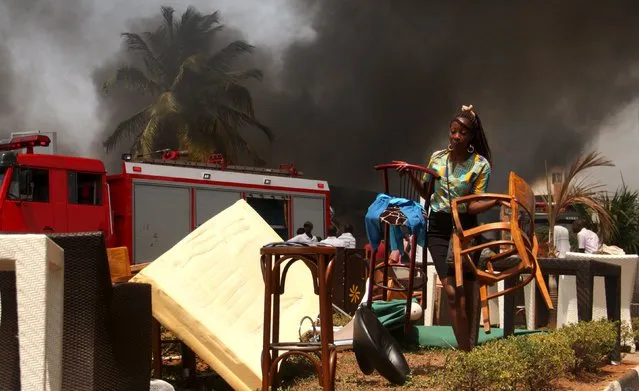 A worker secures furniture from the burning Chinese-owned T2000 supermarket in Burundi's capital Bujumbura, September 21, 2015. (Photo by Evrard Ngendakumana/Reuters)