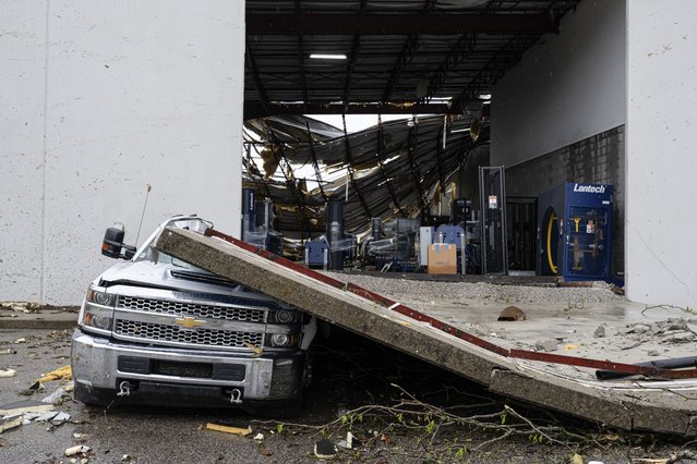 A damaged truck sits under a section of collapsed warehouse wall after violent storms and tornadoes tore through the area on Thursday, April 3, 2025, in Jeffersontown, KY. (Photo by Jon Cherry/AP Photo)