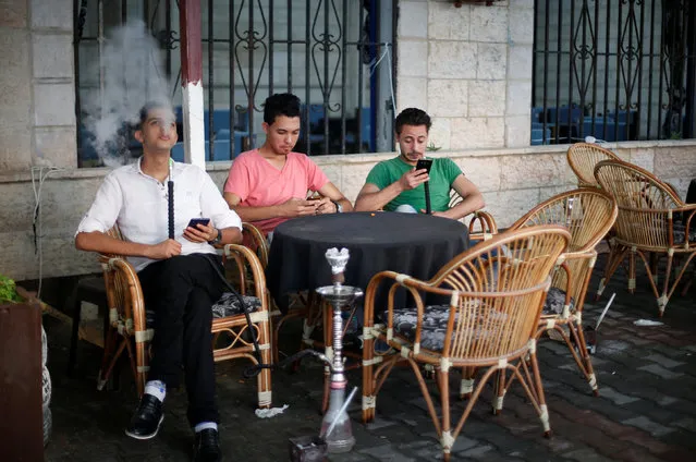 Palestinians smoke shisha or hookah (waterpipe) at a coffee shop in Gaza City July 17, 2016. (Photo by Suhaib Salem/Reuters)