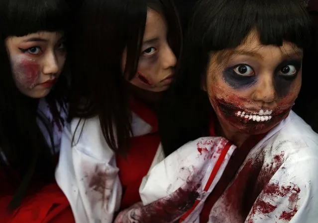 Participants in costumes pose for pictures after a Halloween parade in Kawasaki, south of Tokyo, October 26, 2014. (Photo by Yuya Shino/Reuters)