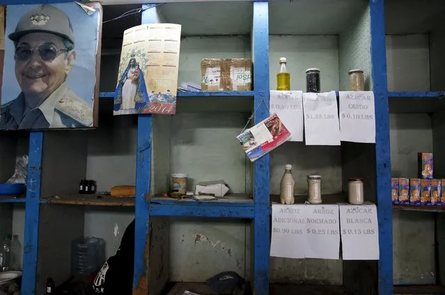 A photograph of Cuba's President Raul Castro hangs next to samples of basic products like rice, sugar and oil that are on sale at a subsidised state store, or “bodega”, where Cubans can buy with a ration book they receive annually from the government in Havana September 18, 2015. (Photo by Carlos Garcia Rawlins/Reuters)