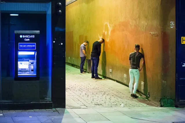 Three men urinate in an alleyway off of Market Street in Manchester, UK on September 11, 2016. (Photo by Joel Goodman/London News Pictures)