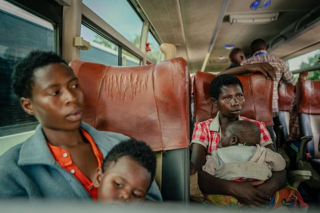 Two Displaced persons, presumed to be Rwandan nationals, sit in a large bus with there children after undergoing checks at the border, between the Democratic Republic of Congo and Rwanda, in Goma on May 19, 2025. They were transported by United Nations High Commissioner for Refugees (UNHCR) vehicles as part of their repatriation to Rwanda. (Photo by Jospin Mwisha/AFP Photo)