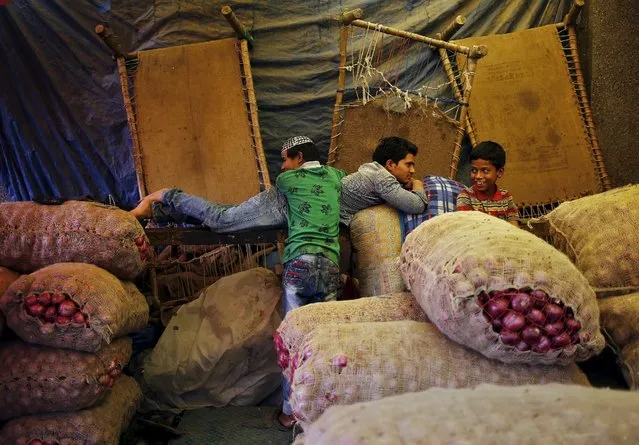 People rest next to stacked sacks of onions at a wholesale vegetable market in New Delhi, India, October 14, 2015. (Photo by Anindito Mukherjee/Reuters)