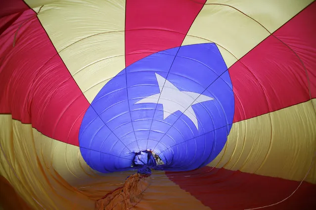 People inflate a hot air balloon with a design of the Estelada, the Catalan separatist flag, during the European Ballon Festival in Igualada July 11, 2014. (Photo by Albert Gea/Reuters)