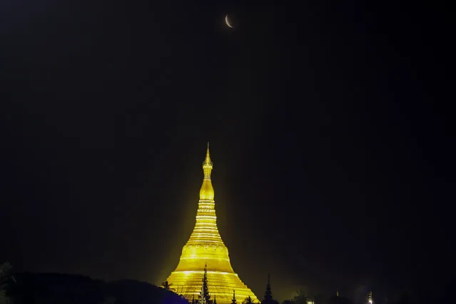 The moon rises above Myanmar Landmark Shwedagon pagoda during a lunar eclipse in Yangon, Myanmar, Tuesday, November 8, 2022. (Photo by Thein Zaw/AP Photo)
