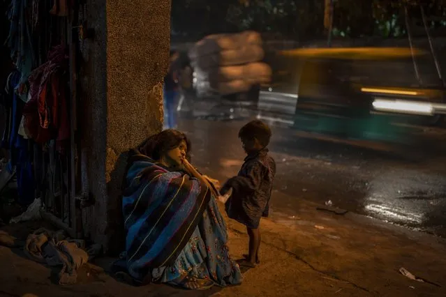 A homeless woman sits by the entrance to the a dilapidated shelter for homeless people in New Delhi, December 30, 2022. The piercing chill is an ordeal for the city’s homeless, with New Delhi Sunday recording the minimum temperature of 5.5 degrees Celsius (41.9 Fahrenheit). New Delhi's 195 homeless shelters can accommodate only about 19,000 people, leaving tens of thousands struggling to keep warm. (Photo by Altaf Qadri/AP Photo)