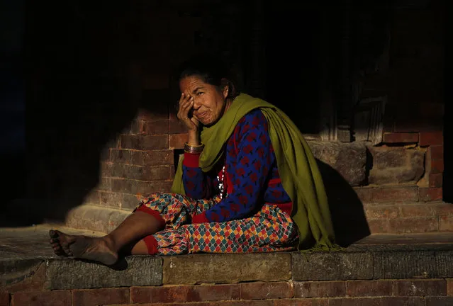 Light illuminates a woman sitting near a temple in Kathmandu, Nepal January 18, 2016. (Photo by Navesh Chitrakar/Reuters)